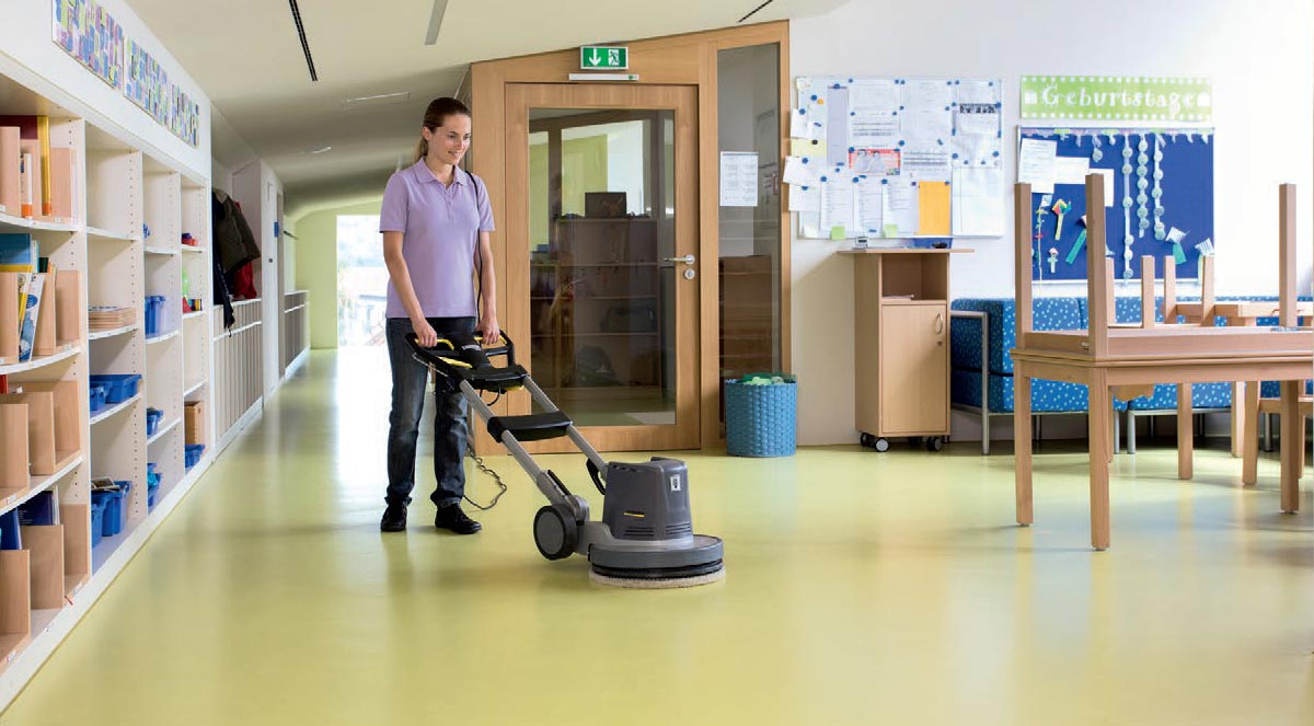 Profesjonalna szorowarka BDP 43/450 C Adv firmy Karcher Profesjonalne urządzenie do szorowania podłóg BDP 43/450 C Adv firmy Karcher. Kobieta szorująca podłogę w przedszkolu. Podłoga wyłożona linoleum .