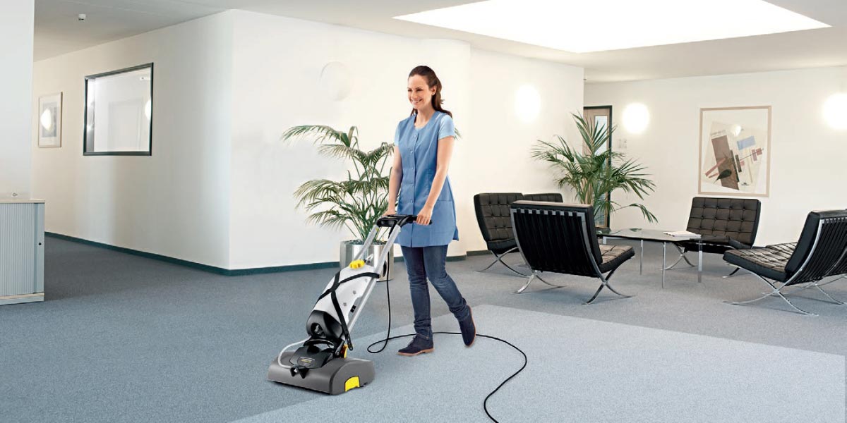 Profesjonalne, kompaktowe urządzenie do czyszczenia zasadniczego BRS 43/500 C firmy Karcher Profesjonalne, kompaktowe urządzenie do czyszczenia wykładzin BRS 43/500 C firmy Karcher. Kobieta czyszcząca wykładzinę podłogową na korytarzu w budynku biurowym przy pomocy BRS 43/500 C firmy Karcher.