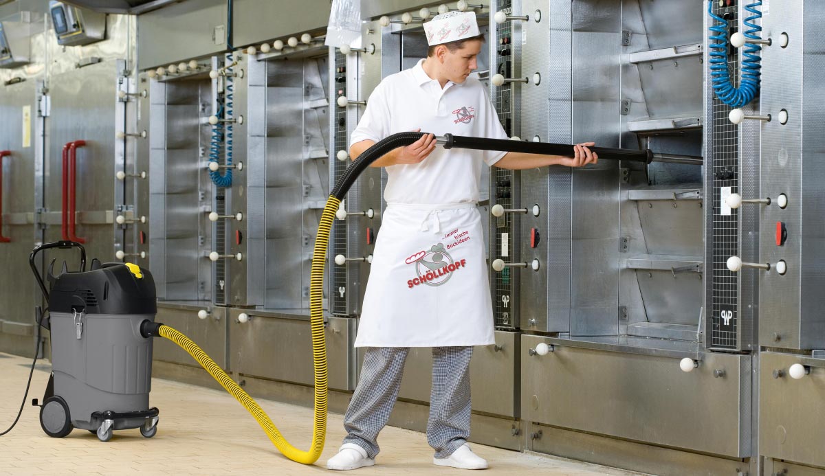 Profesjonalny odkurzacz specjalistyczny NT 35/1 Tact Bs firmy Karcher Profesjonalny odkurzacz specjalistyczny NT 35/1 Tact Bs firmy Karcher. Mężczyzna odkurza profesjonalny piec cukierniczy przy pomocy odkurzacza NT 35/1 Tact Bs.