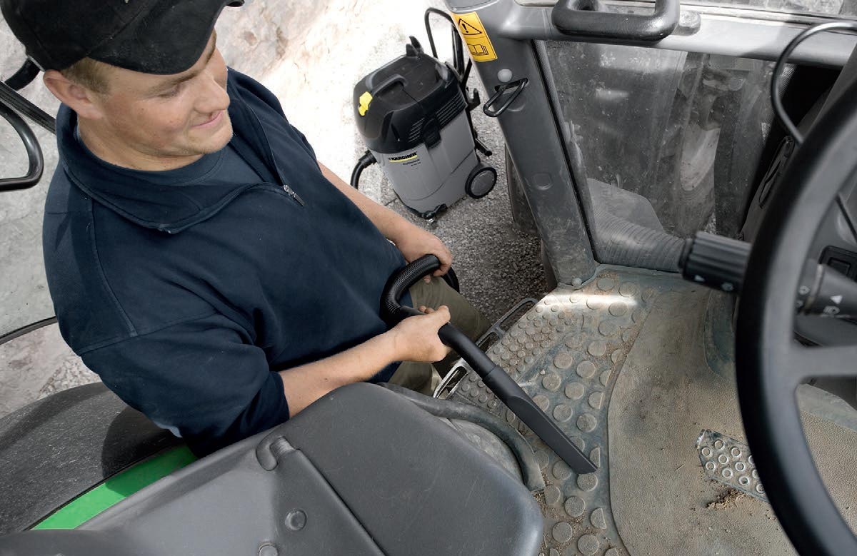 Profesjonalny odkurzacz specjalistyczny NT 55/1 Tact Bs firmy Karcher Profesjonalny odkurzacz specjalistyczny NT 55/1 Tact Bs firmy Karcher. Mężczyzna odkurza samochód ciężarowy przy pomocy odkurzacza NT 55/1 Tact Bs.