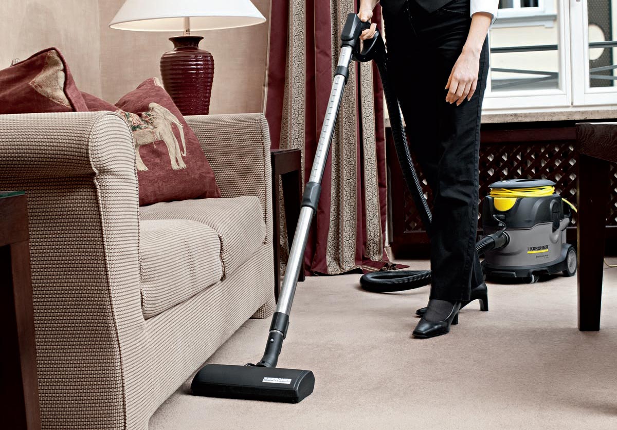 Profesjonalny odkurzacz jednofunkcyjny T 15/1 HEPA + ESB 28 firmy Karcher Profesjonalny odkurzacz jednofunkcyjny T 15/1 HEPA + ESB 28 firmy Karcher. Kobieta podczas odkurzania podłogi w pokoju hotelowym przy pomocy T 15/1 wyposażonego w filtr HEPA oraz elektroszczotkę ESB 28.