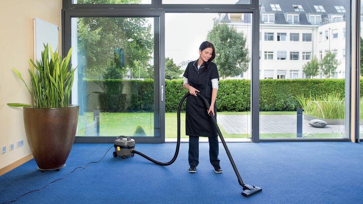 Profesjonalny odkurzacz jednofunkcyjny T 7/1 Classic firmy Karcher Profesjonalny odkurzacz jednofunkcyjny T 7/1 Classic firmy Karcher. Kobieta odkurzający wykładzinę podłogową..